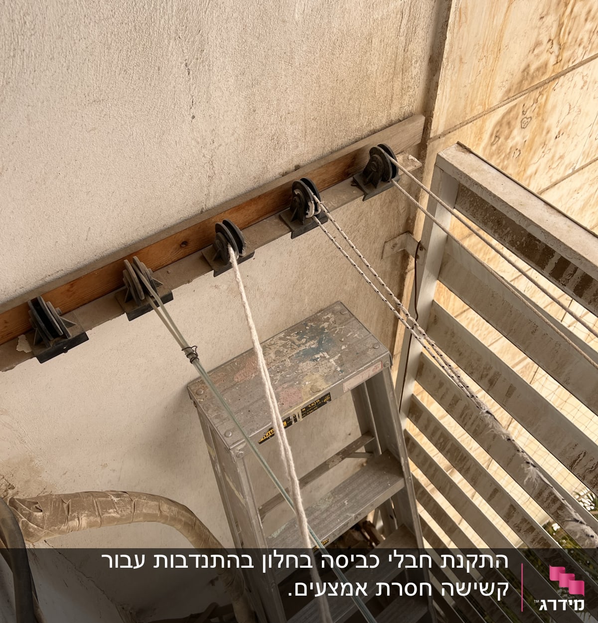 סולם מתכת, גלגלות וחבלים על קיר